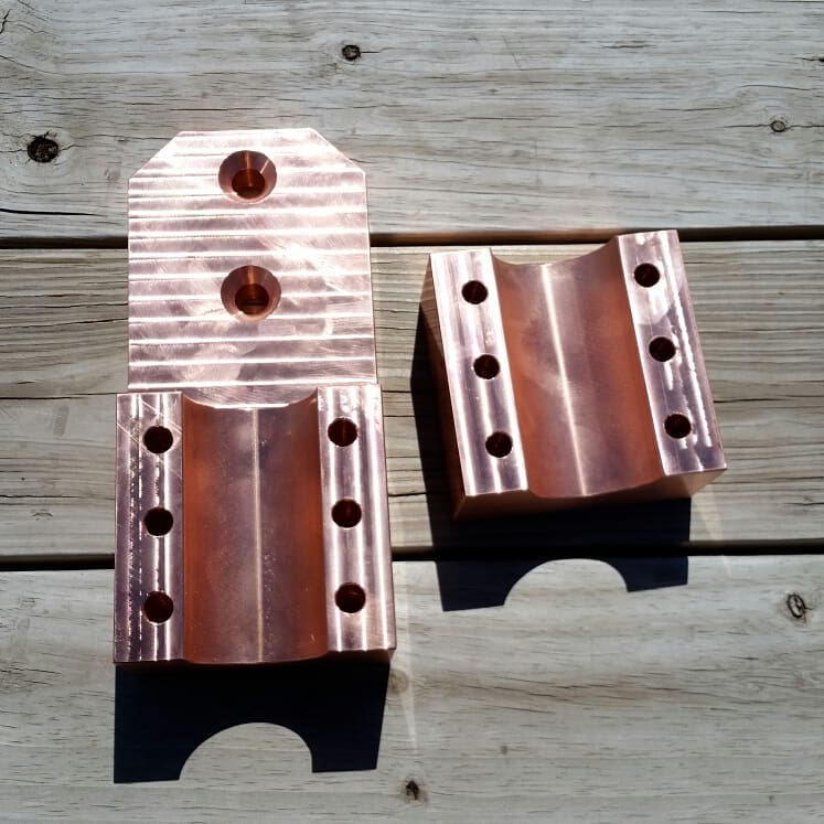 Two solid copper electrical connector blocks machined from 2x4x9 inch bar