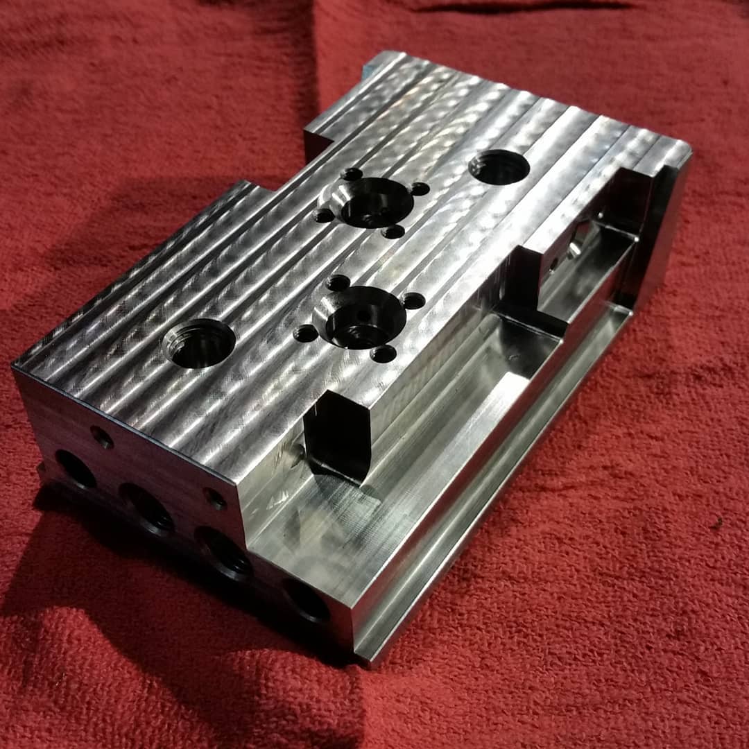 Precision-milled 17-4 heat-treated stainless block with bored holes and pockets