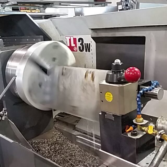 Haas TL-3W lathe turning a large round workpiece with coolant lines attached